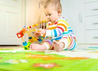 Baby plays with an educational toy. Selective focus.