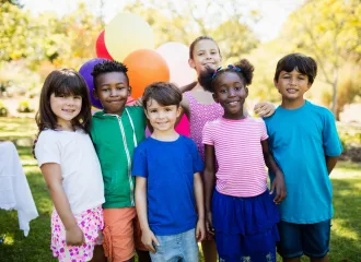 Cute children standing and posing during a birthday party on a park